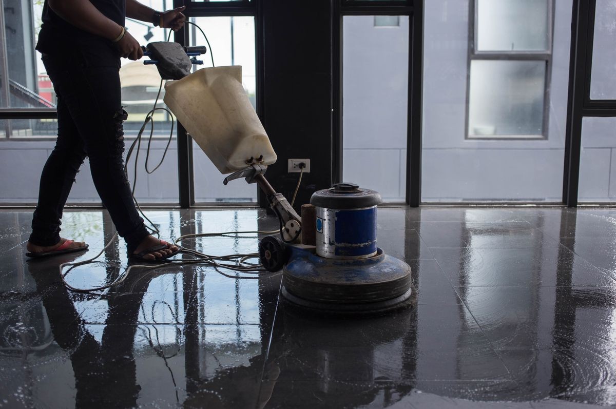 The people cleaning floor with machine.